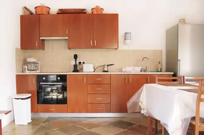 a kitchen with wooden cabinets and a stove at I Plateia in Kalopanayiotis