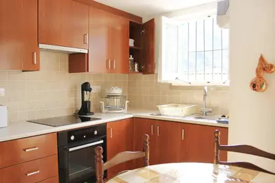 a kitchen with wooden cabinets and a table and a window at I Plateia in Kalopanayiotis