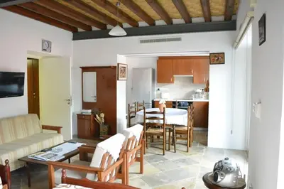 a living room and kitchen with a table and chairs at I Plateia in Kalopanayiotis