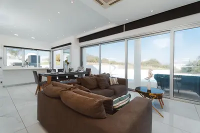 a living room with a couch and a table at Seaside Luxury Villa with Heated Pool in Paralimni