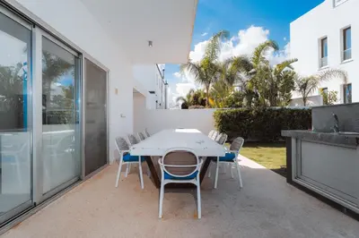 a white table and chairs on a patio at Seaside Luxury Villa with Heated Pool in Paralimni