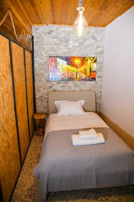 a bed in a room with a painting on the wall at Sophias Cottage in Askas