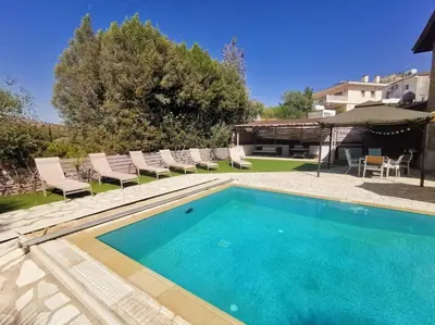 a swimming pool in a yard with chairs at Unique Stonehouse Traditional Villa in Ayia Anna in Ayia Anna