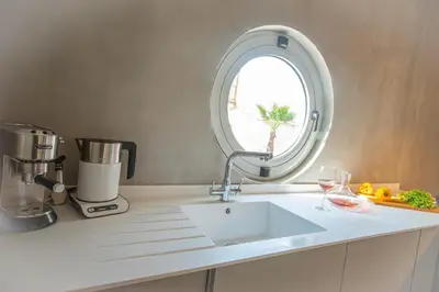 a kitchen counter with a sink and a mirror at Protaras Art House Seviews in Protaras