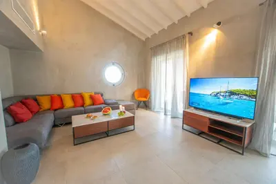 a living room with a couch and a large television at Protaras Art House Seviews in Protaras
