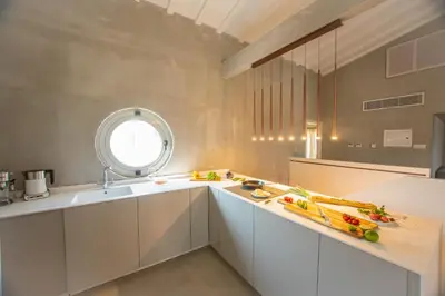 a kitchen with white cabinets and a window at Protaras Art House Seviews in Protaras