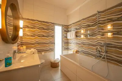 a bathroom with a sink and a tub and a toilet at Protaras Art House Seviews in Protaras
