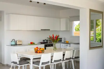 a white kitchen with a white table and chairs at Ayia Napa Marina Vibes in Ayia Napa