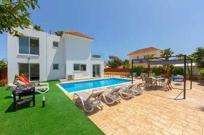 a villa with a swimming pool and a house at Ayia Napa Marina Vibes in Ayia Napa