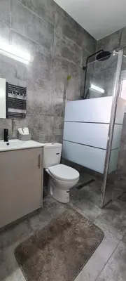 a bathroom with a toilet and a sink and a shower at Cozy Apartment by the sea in Limassol