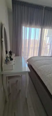 a bedroom with a bed and a table with a mirror at Cozy Apartment by the sea in Limassol