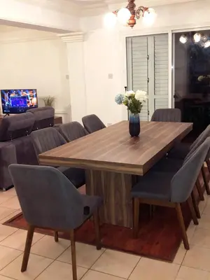a wooden table with chairs and a vase of flowers on it at Villa Elena in Protaras