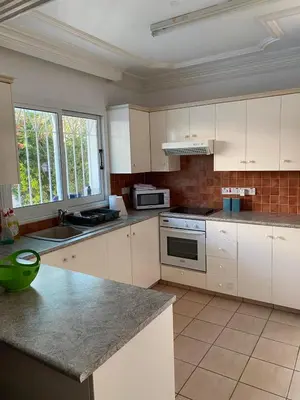 a kitchen with white cabinets and a counter top at Villa Elena in Protaras