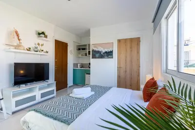 a bedroom with a large bed and a television at Sofia's Cosy Studio in Larnaca in Larnaka