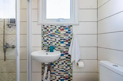 a bathroom with a sink and a window at Sofia's Cosy Studio in Larnaca in Larnaka