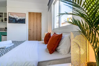 a bedroom with a bed with pillows and a window at Sofia's Cosy Studio in Larnaca in Larnaka