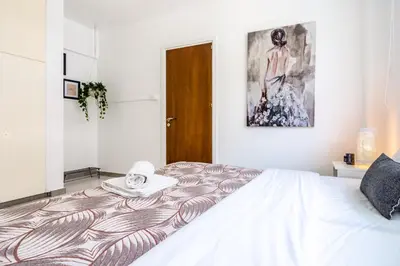 a bedroom with a bed and a painting on the wall at Mila's 1-BR Apartment in Larnaca in Larnaka