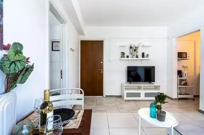 a living room with a table and a tv at Mila's 1-BR Apartment in Larnaca in Larnaka