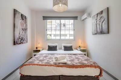 a bedroom with a large bed with a window at Mila's 1-BR Apartment in Larnaca in Larnaka