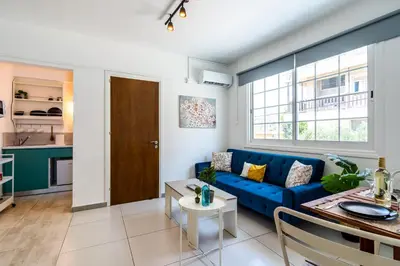 a living room with a blue couch and a table at Mila's 1-BR Apartment in Larnaca in Larnaka