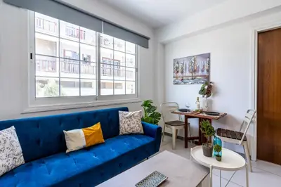 a living room with a blue couch and a table at Mila's 1-BR Apartment in Larnaca in Larnaka