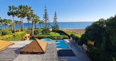 a resort with a swimming pool next to the beach at Villa del Mar Heated pool in Mazotos