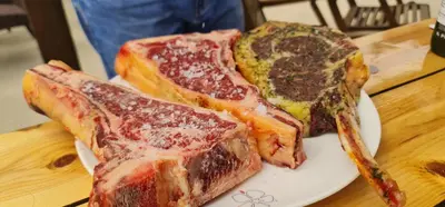 two pieces of meat on a white plate on a table at Villa del Mar Heated pool in Mazotos