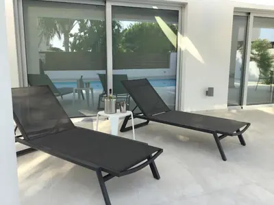 two black chairs sitting on a patio with a table at Katikies Grand in Pissouri