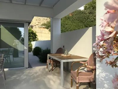 a patio with a table and chairs on a patio at Katikies Grand in Pissouri