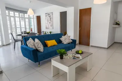 a blue couch in a living room with a table at Jana's 2-BR Apartment in Larnaca in Larnaka