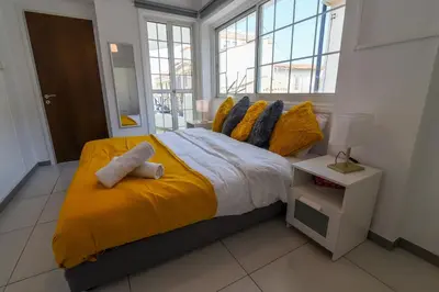 a bedroom with a large bed with yellow sheets and pillows at Jana's 2-BR Apartment in Larnaca in Larnaka