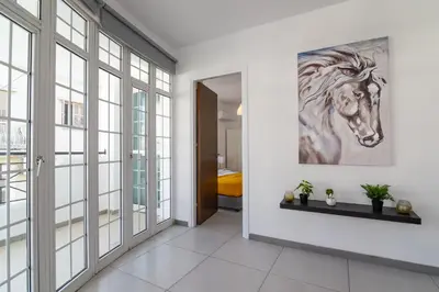 a hallway with a painting of a horse on the wall at Jana's 2-BR Apartment in Larnaca in Larnaka