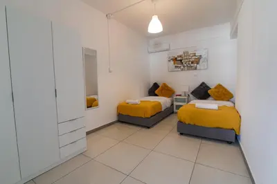 a bedroom with two beds and a mirror at Jana's 2-BR Apartment in Larnaca in Larnaka