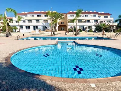a swimming pool in a resort with buildings in the background at NISSI BEACH AYIA NAPA Pool View Apartment Large Terrace 450m from Nissi Beach in Ayia Napa