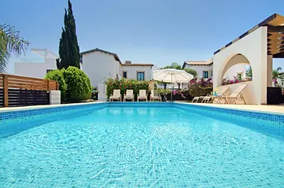 a swimming pool in front of a house at Villa Greko in Protaras