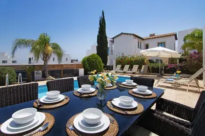 a blue table with hats and plates on it at Villa Greko in Protaras
