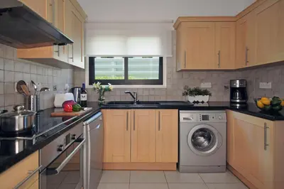 a kitchen with a washing machine and a sink at Villa Greko in Protaras