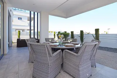 a dining room with a table and wicker chairs at Villa Theresa in Protaras