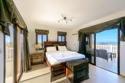 a bedroom with a bed and a balcony at Amani Villa in Protaras