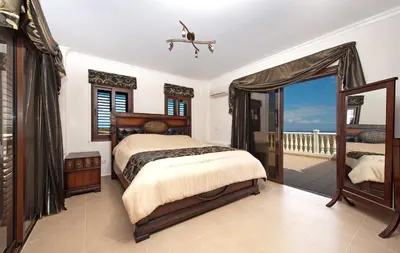 a bedroom with a bed and a balcony at Amani Villa in Protaras