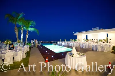 an outdoor wedding venue with a swimming pool at night at Bay View Villa in Protaras