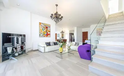 a living room with a purple couch and a staircase at Bay View Villa in Protaras