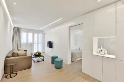 a white living room with a couch and a bed at City Centre Studio Apartments Nicosia in Nicosia