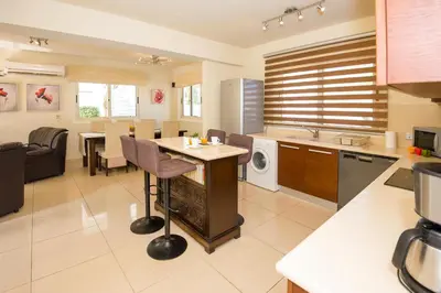 a kitchen and living room with a table and chairs at Villa Athena in Protaras
