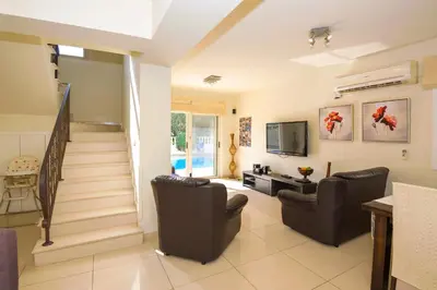 a living room with two chairs and a staircase at Villa Athena in Protaras