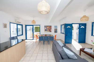 a living room with blue doors and a table at Villa Saint Nikolas in Protaras