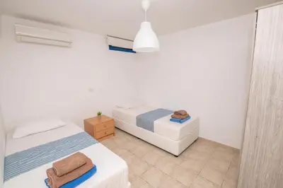 a white room with two beds and a window at Villa Saint Nikolas in Protaras
