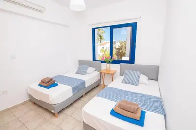 two beds in a room with a window at Villa Saint Nikolas in Protaras