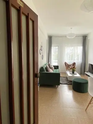 a living room with a green couch and a table at Boho-Chic one bedroom flat in Engomi in Engomi