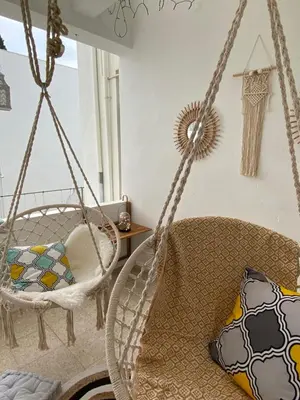 a swing in a living room with a pillow at Boho-Chic one bedroom flat in Engomi in Engomi